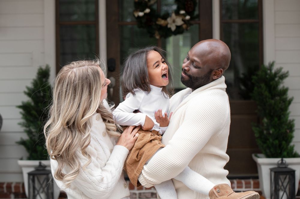 A joyous group shares laughter and embraces during what appears to be an emotional celebration moment outdoors.