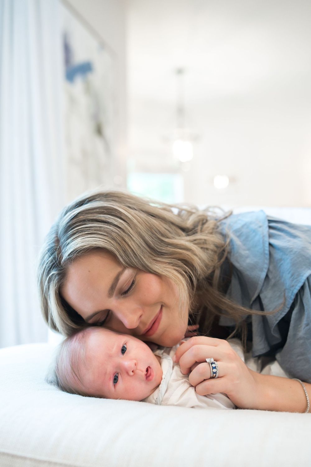A mother and baby resting together peacefully on a light-colored surface in natural daylight.