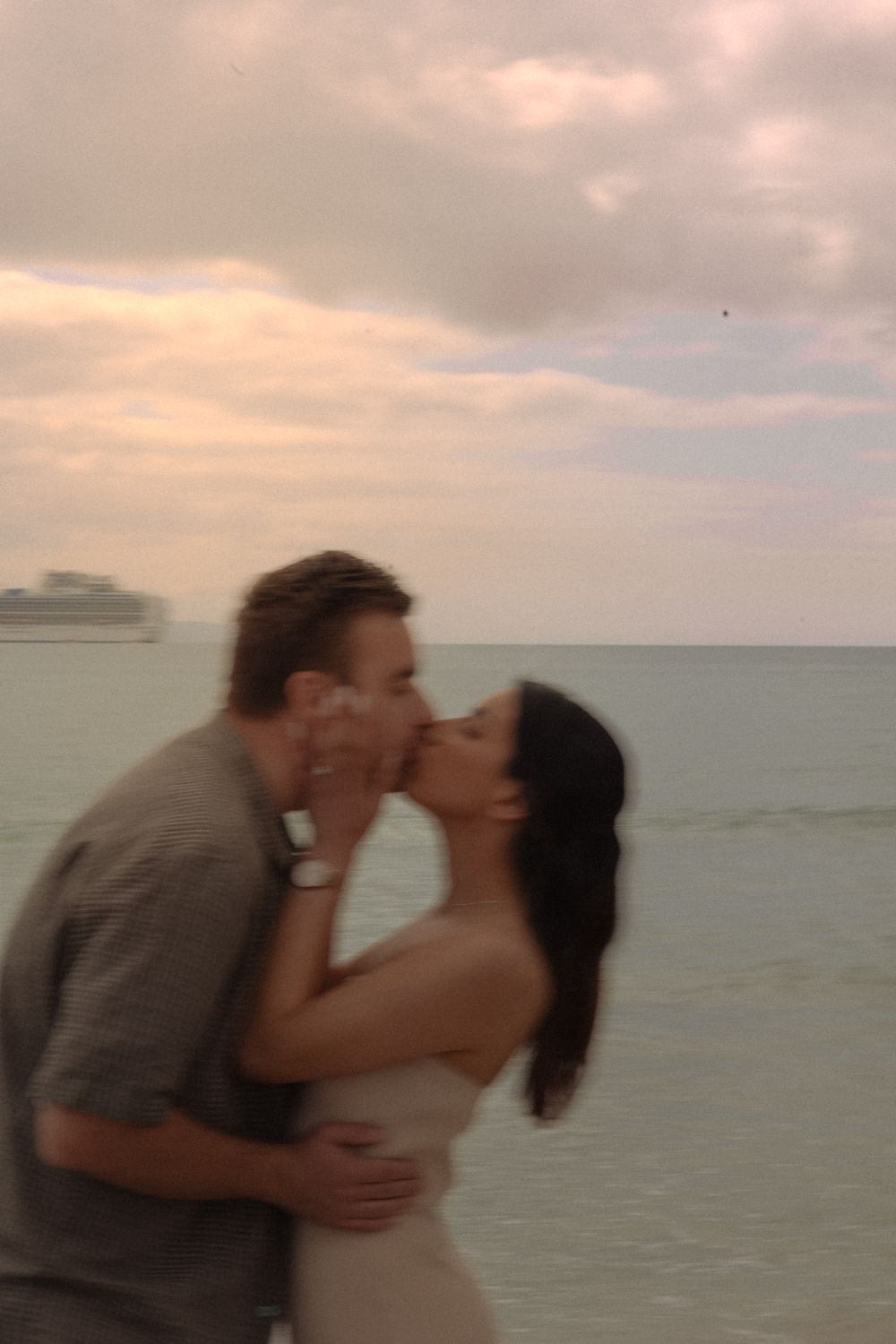 Couple sharing a romantic moment at sunset by the ocean.
