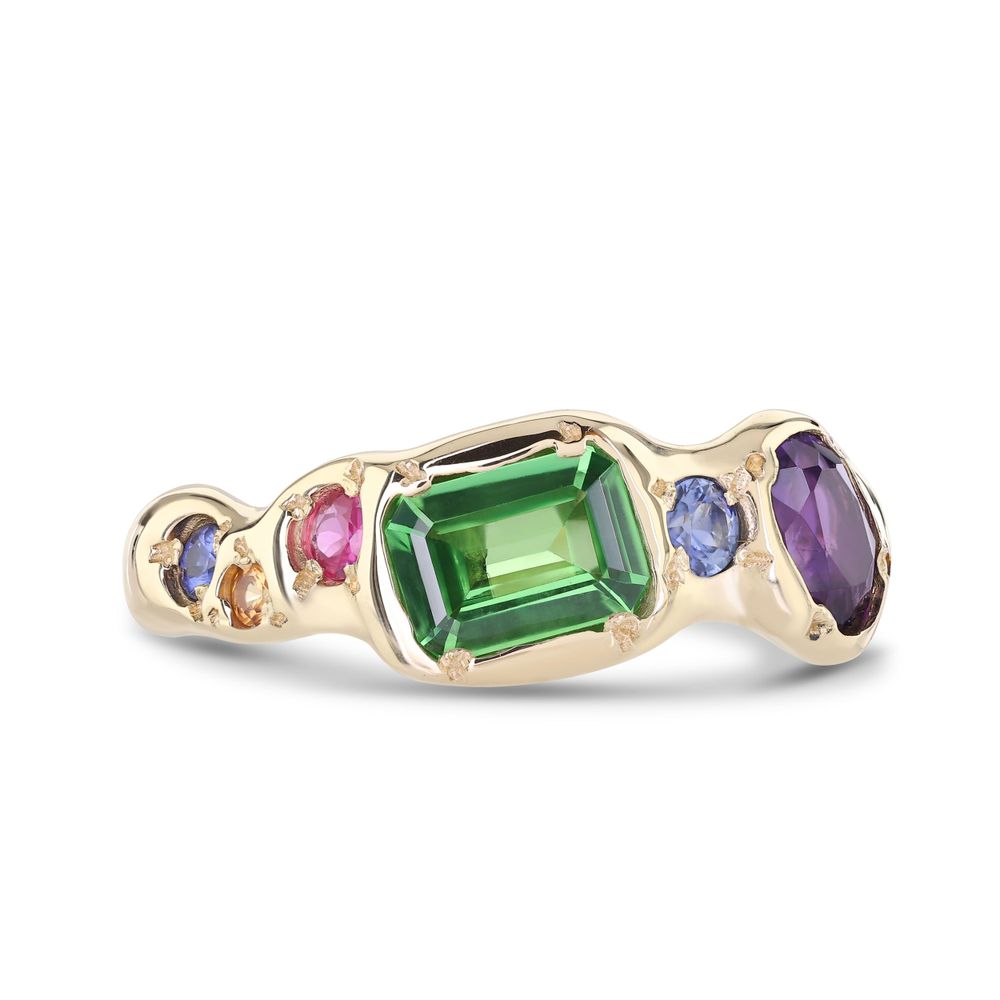 Gold ring with emerald-cut green tourmaline centerpiece accented by blue sapphires and amethyst gemstones.