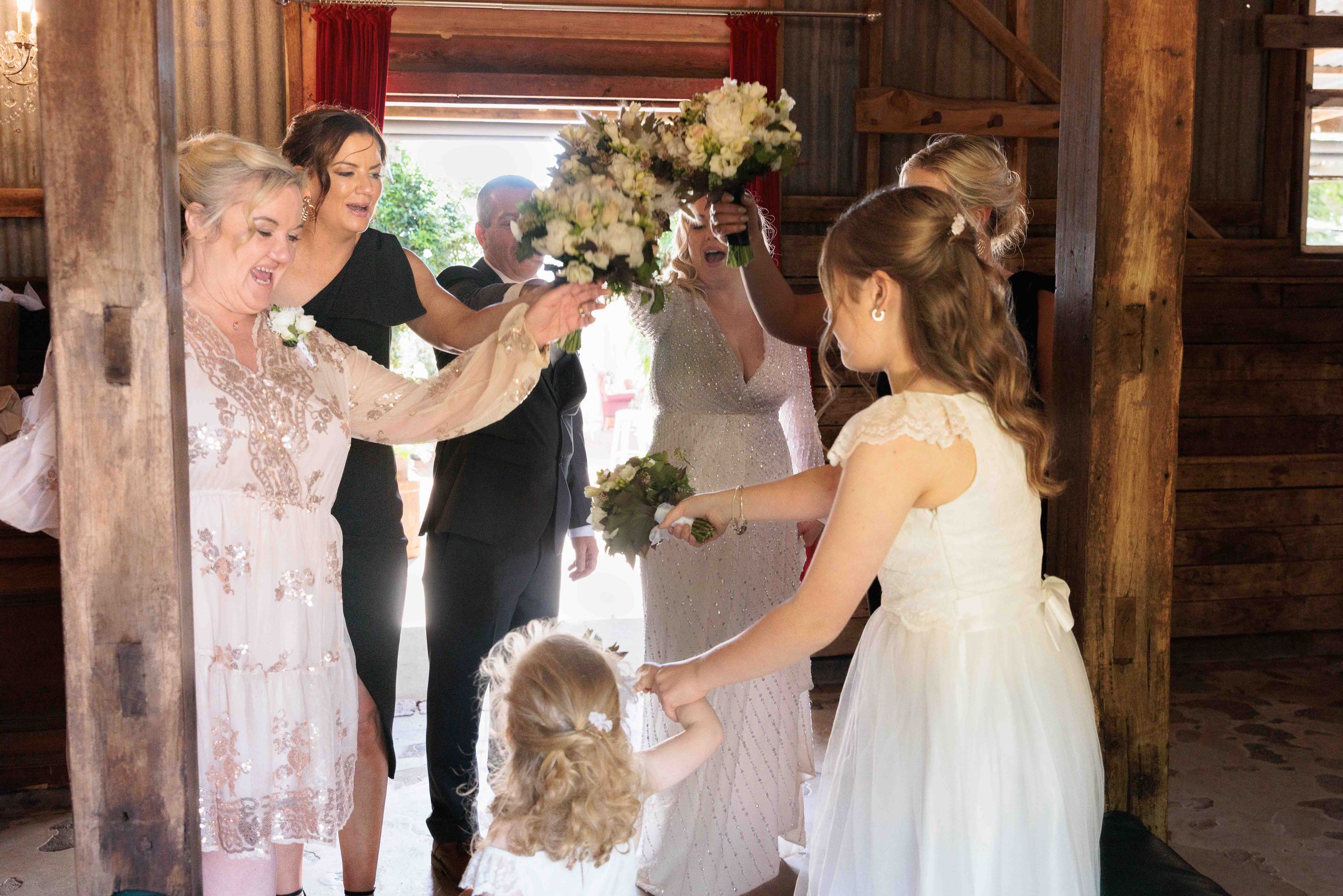 Bride and bridesmaids and family toasting with flowers.L