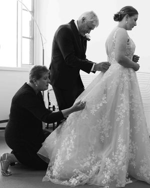 Mum and Dad help fix the back of their daughter's  wedding dress
