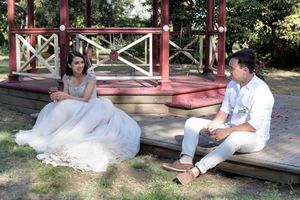 After the wedding and before the reception, couple sit on a step and enjoy a drink together.