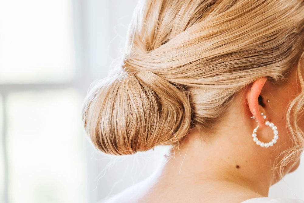 Bride detail shot of bun and earring in Maine