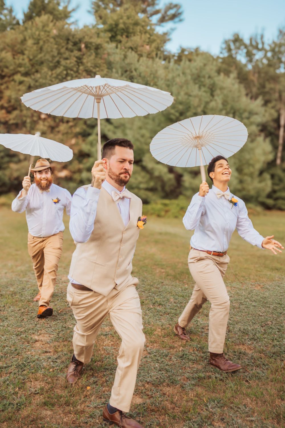 Groom and Groomer running with umbrellas in maine