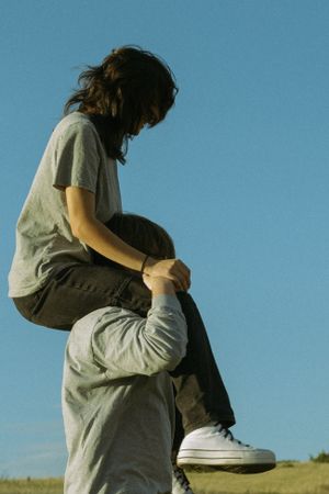 A couple in the foothills of Denver, Colorado, with the girl sitting on his shoulders, enjoying a carefree moment in the mountains.