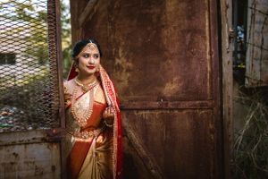 Traditional bridal attire photographed against rustic brick and metal backdrop.