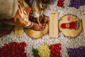 Colorful flower petals and traditional wedding decorations arranged on golden plates.