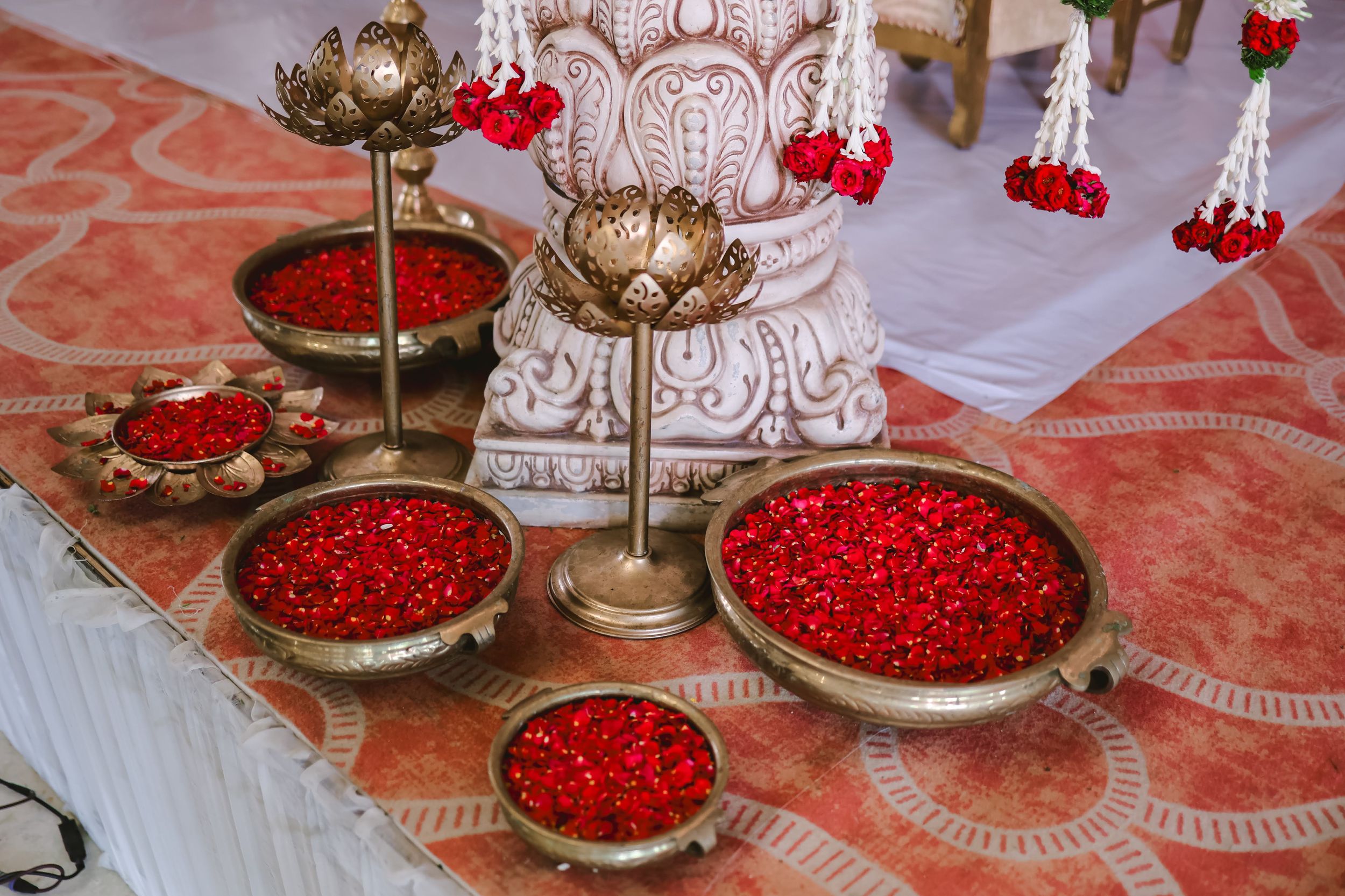 Red berries and decorative elements arranged on an ornate coral-colored tablecloth.