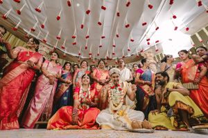 Festive indoor celebration with red decorations hanging from ceiling and gathered guests.