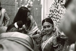 Black and white wedding ceremony photograph with floral decorations and traditional elements.