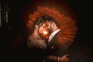 Dramatic dark portrait with glowing orange backlighting creating a romantic silhouette.