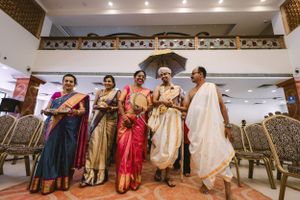 Wedding guests in traditional Indian attire gather and dance during a celebratory event.