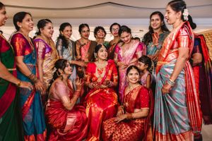 Guests in vibrant saris and traditional outfits celebrate during an Indian wedding reception.