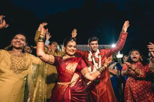 Evening wedding reception with guests dancing and celebrating in traditional Indian outfits.