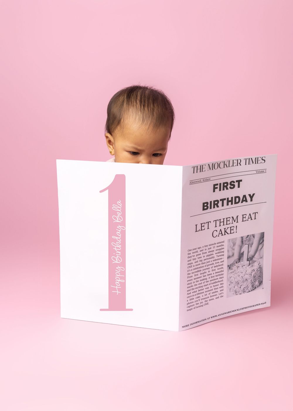 A creative first birthday photo series showing news article style milestone cards against a pink background.