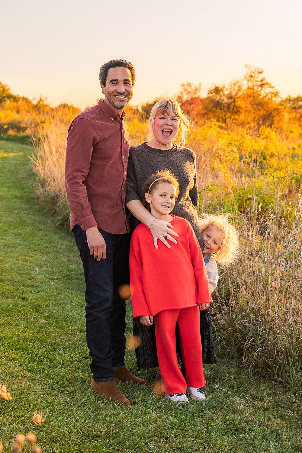 A family group stands together on a path during sunset with golden light.