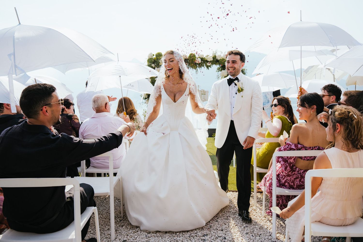 Fashion-style bridal photos on boat with flowing white dress against lake backdrop.