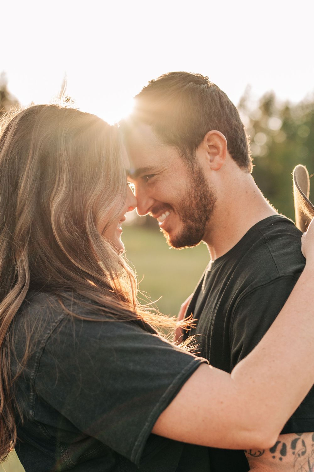 Intimate couple sharing romantic moment in golden sunset light.