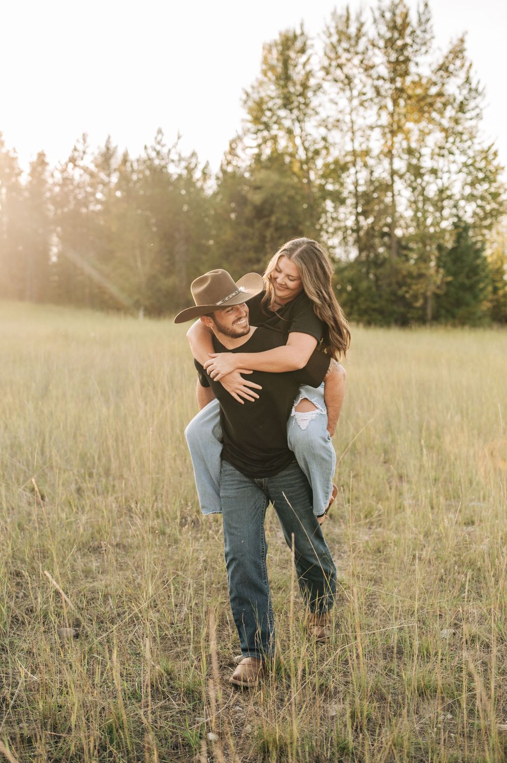 Playful piggyback ride in sunny meadow with pine trees in background.