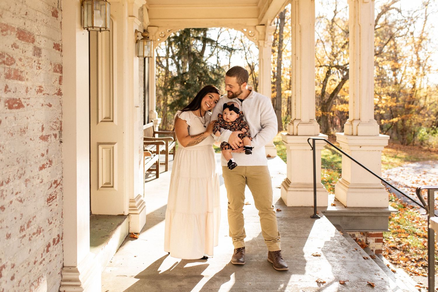 Couple shares tender moment on sunlit porch with their dog.