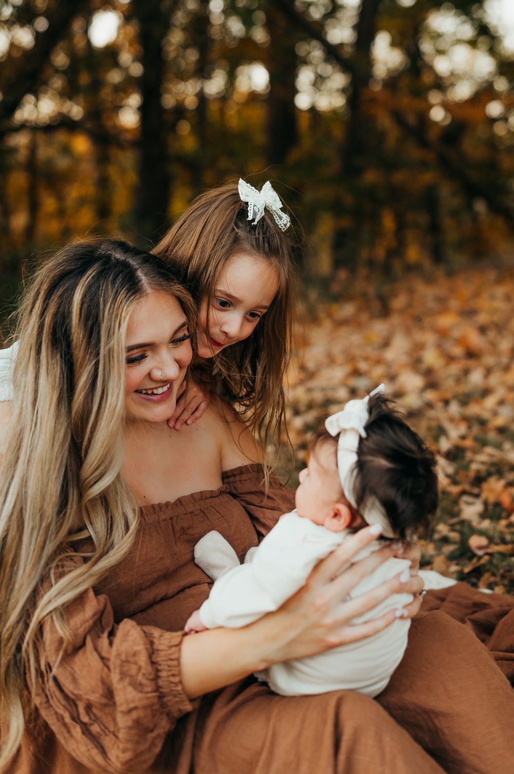 A tender moment captured between family members on fallen autumn leaves.