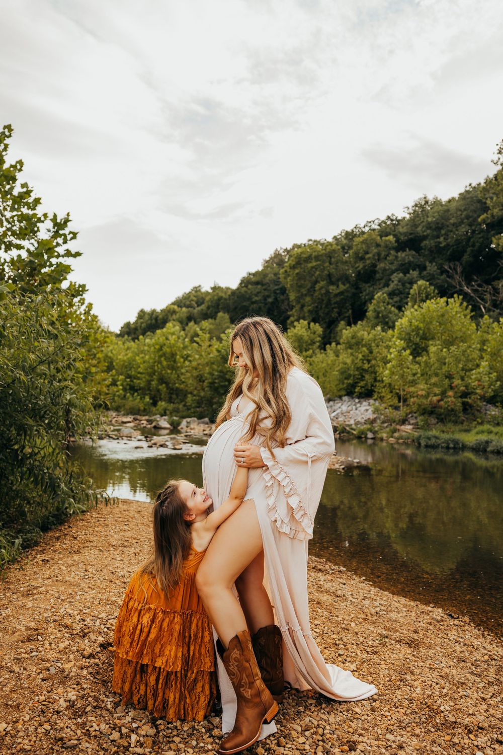 Two people share an intimate moment by a scenic pond surrounded by autumn foliage.