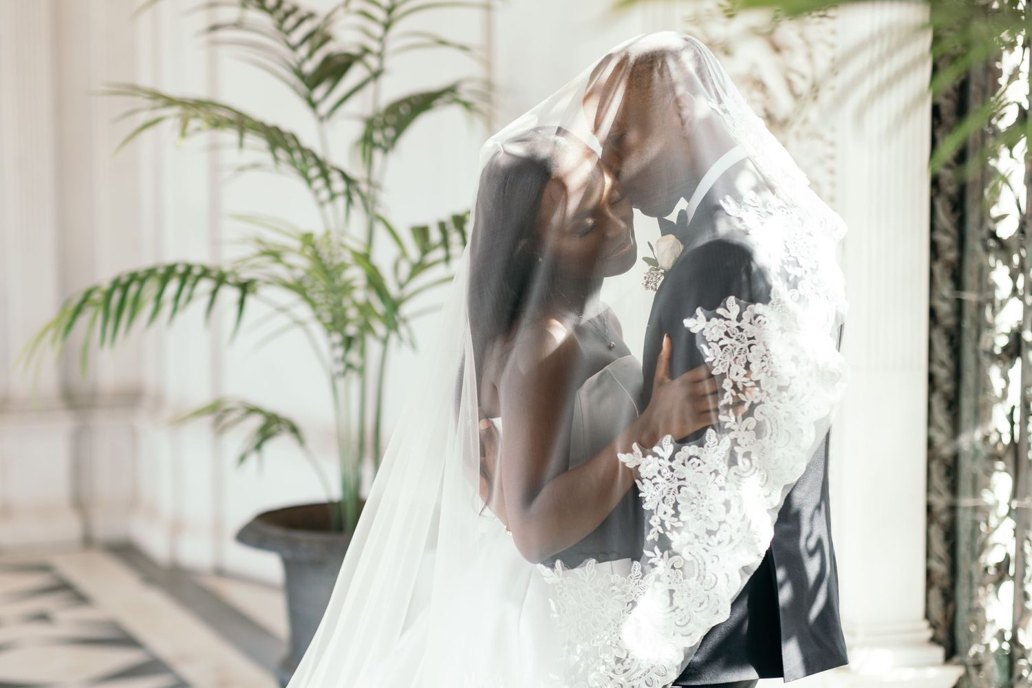 Wedding couple illuminated by vintage lanterns in ornate gothic church interior.