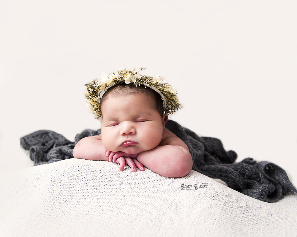 sleepy newborn baby posed in professional photography studio