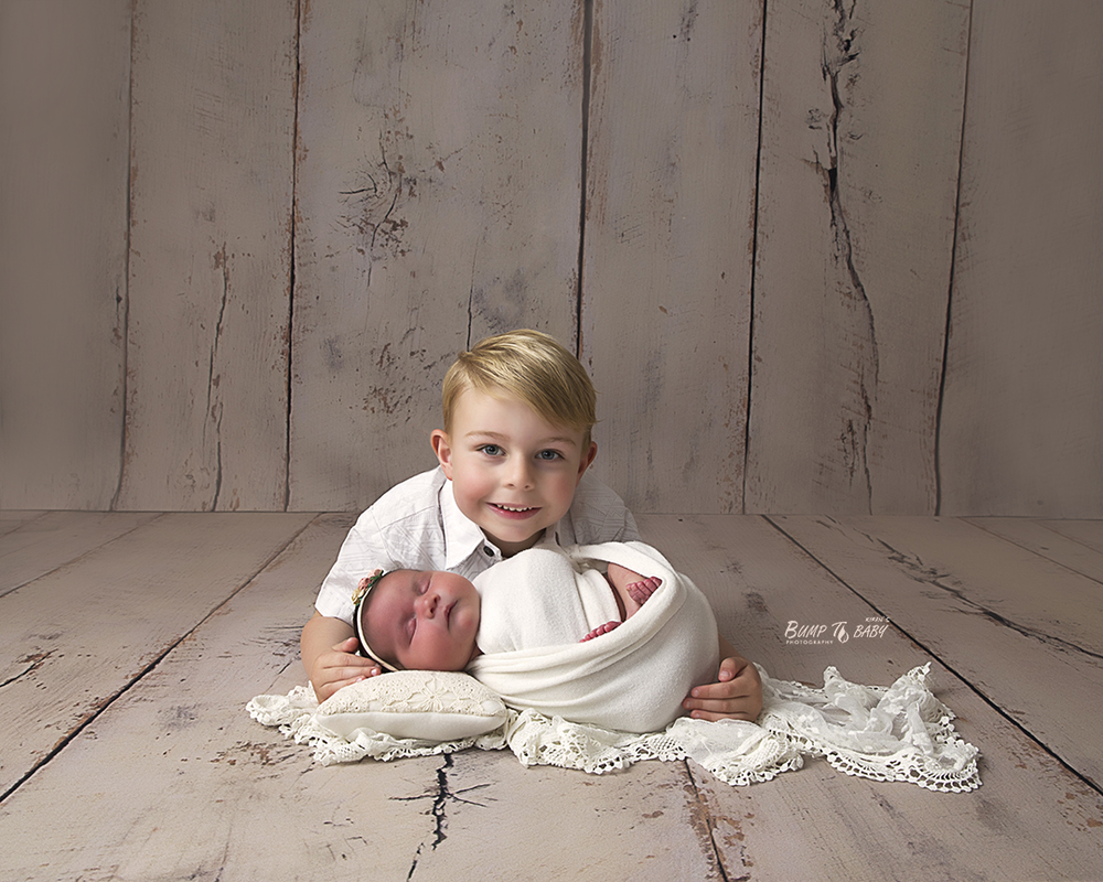 Big brother holding newborn baby sister  in Melbourne east , Croydon studio