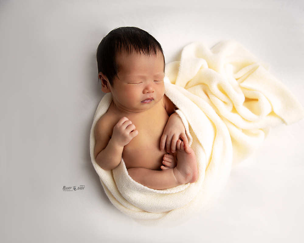 Sleeping newborn baby in a cashmere wrap photographed at a professional Croydon Melbourne newborn studio.