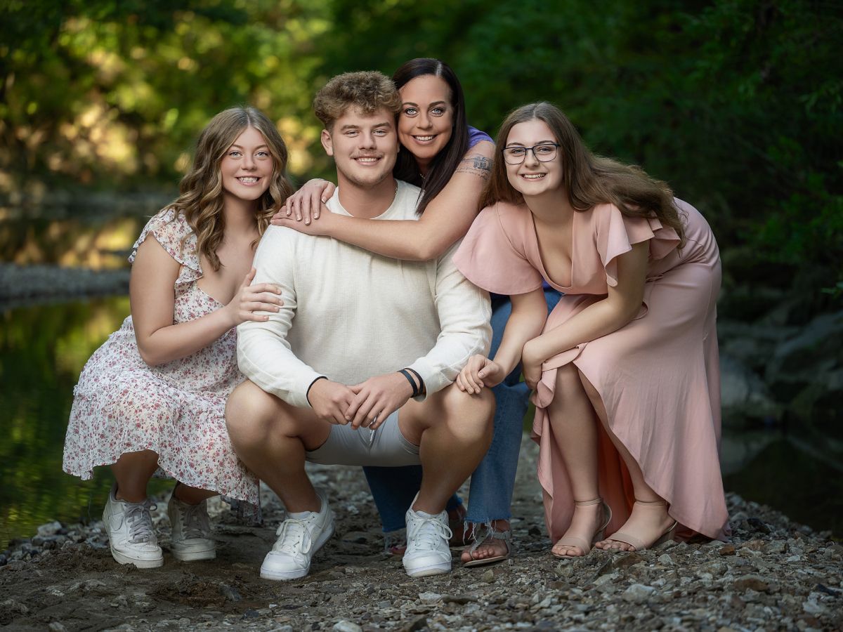 Mother with her children sharing an outdoor family portrait by a wooded creek in Mid-Missouri, photographed by Chris Cleveland Photography.