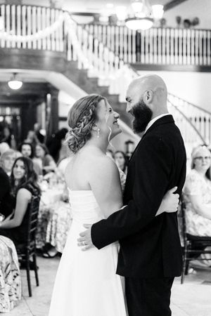 photo of a bride and groom sharing their first dance at a wedding reception with guests seated nearby at the carl house in auburn georgia