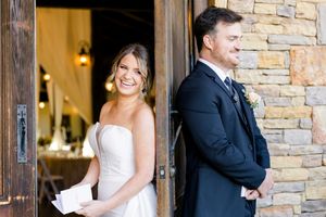 Bride and groom share a first look moment outside rustic stone venue doors on their wedding day at blue mountain vineyards in dahlonega ga