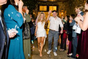 Bride in white mini dress and groom walk through bubble send-off at elegant outdoor wedding at montaluce winery in dahlonega georgia