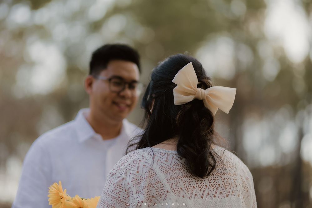 Couple shares a tender moment in a rustic outdoor setting with vibrant sunflowers and soft natural lighting.