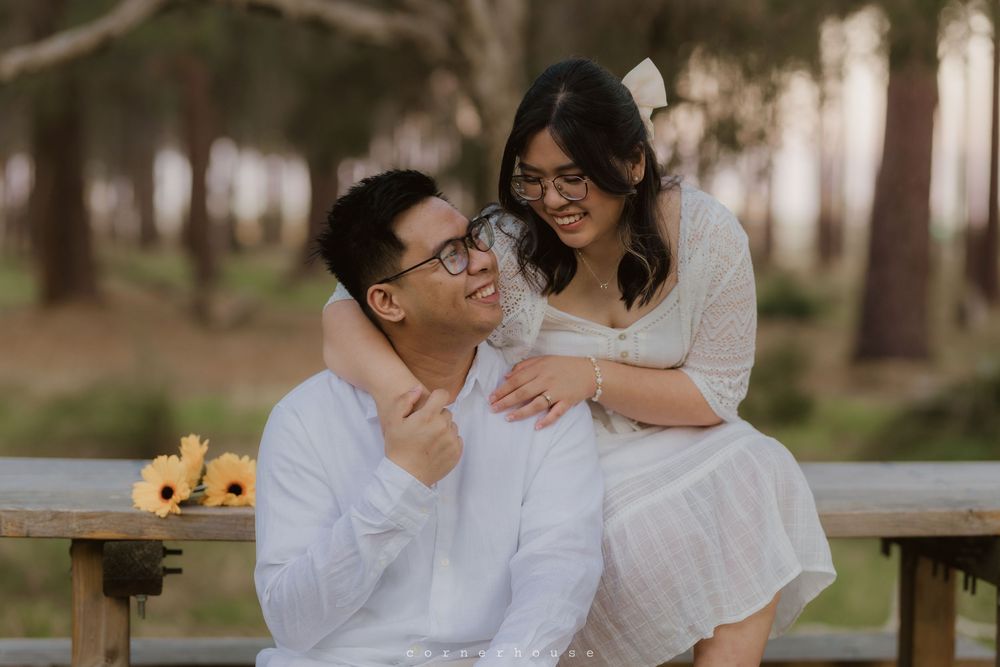 A joyful couple shares tender moments together during a romantic outdoor photoshoot in a natural setting.