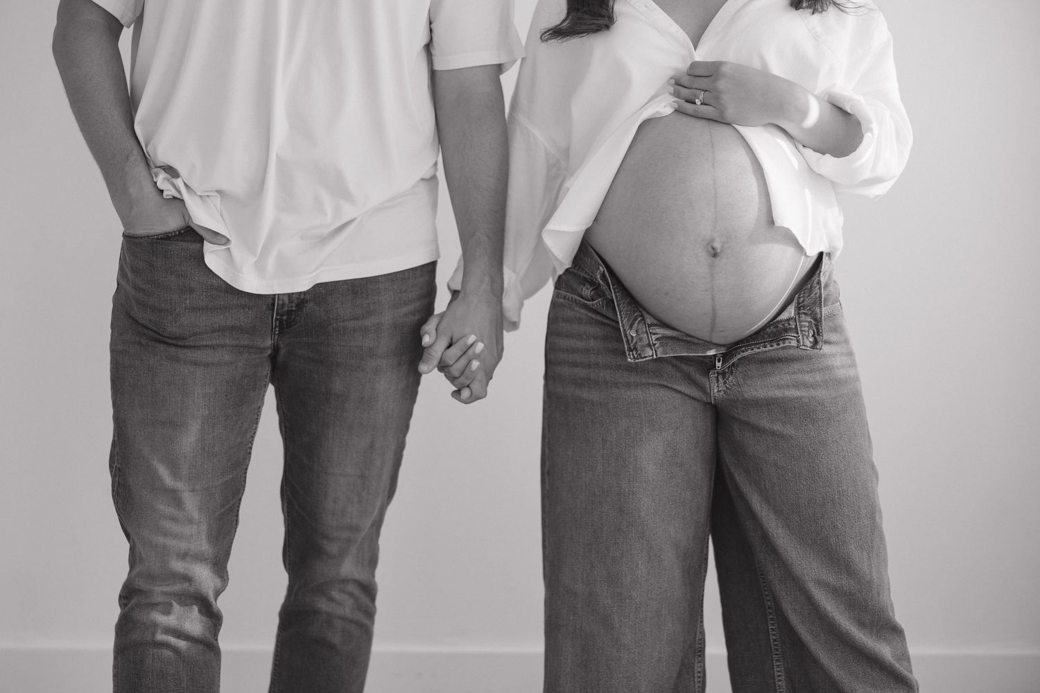Dramatic black and white silhouette of expectant mother against light background.