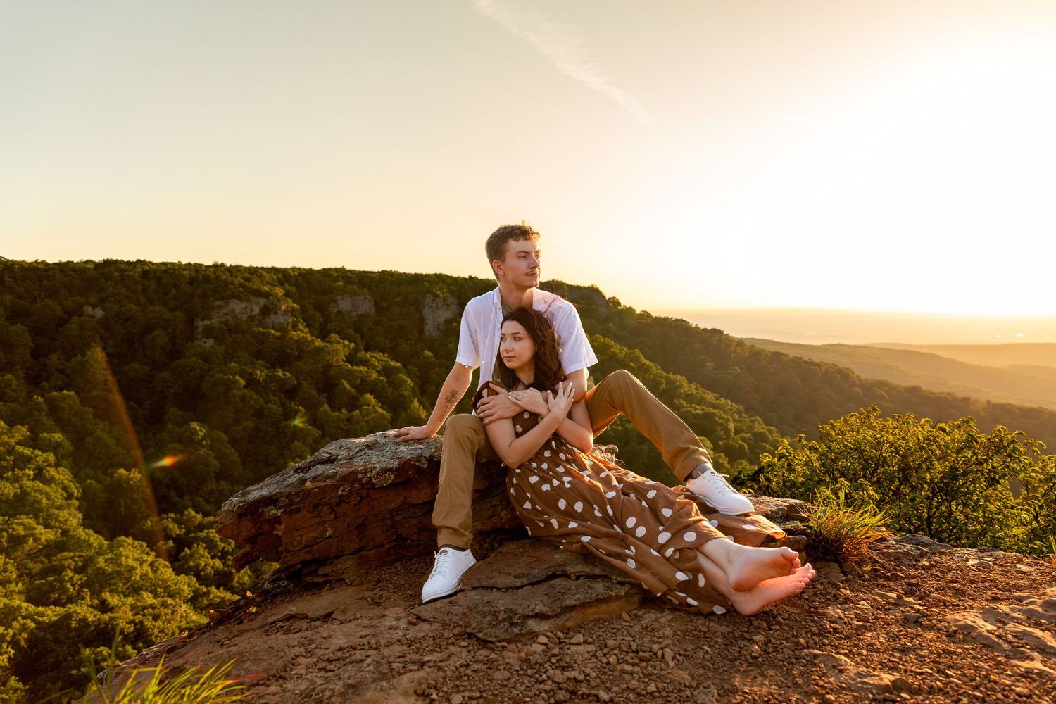 Romantic couple sharing intimate moment at sunset with golden light behind them.