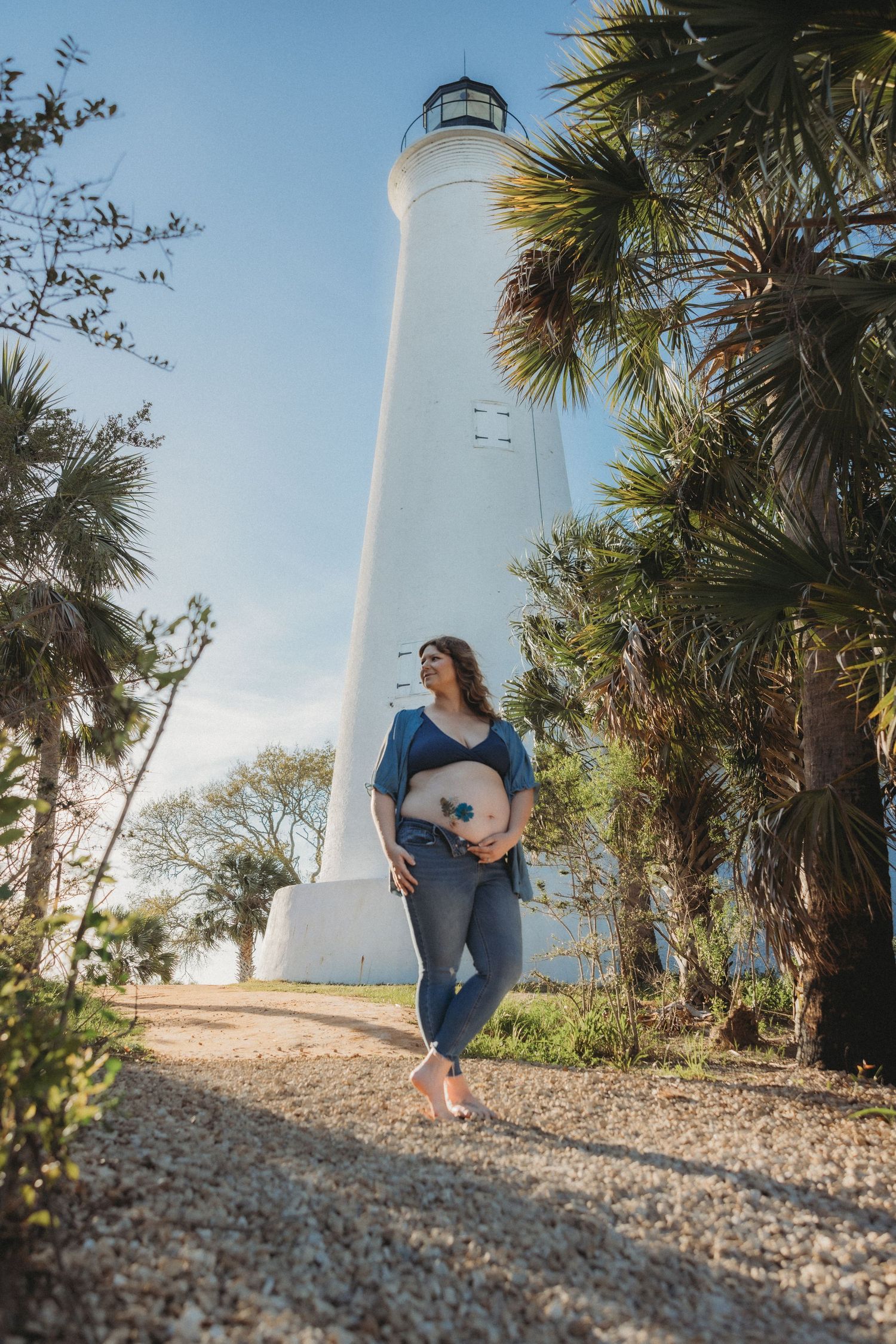 A sequence of photos showing someone in a blue dress walking beside a scenic white lighthouse and palm trees on a sunny day.