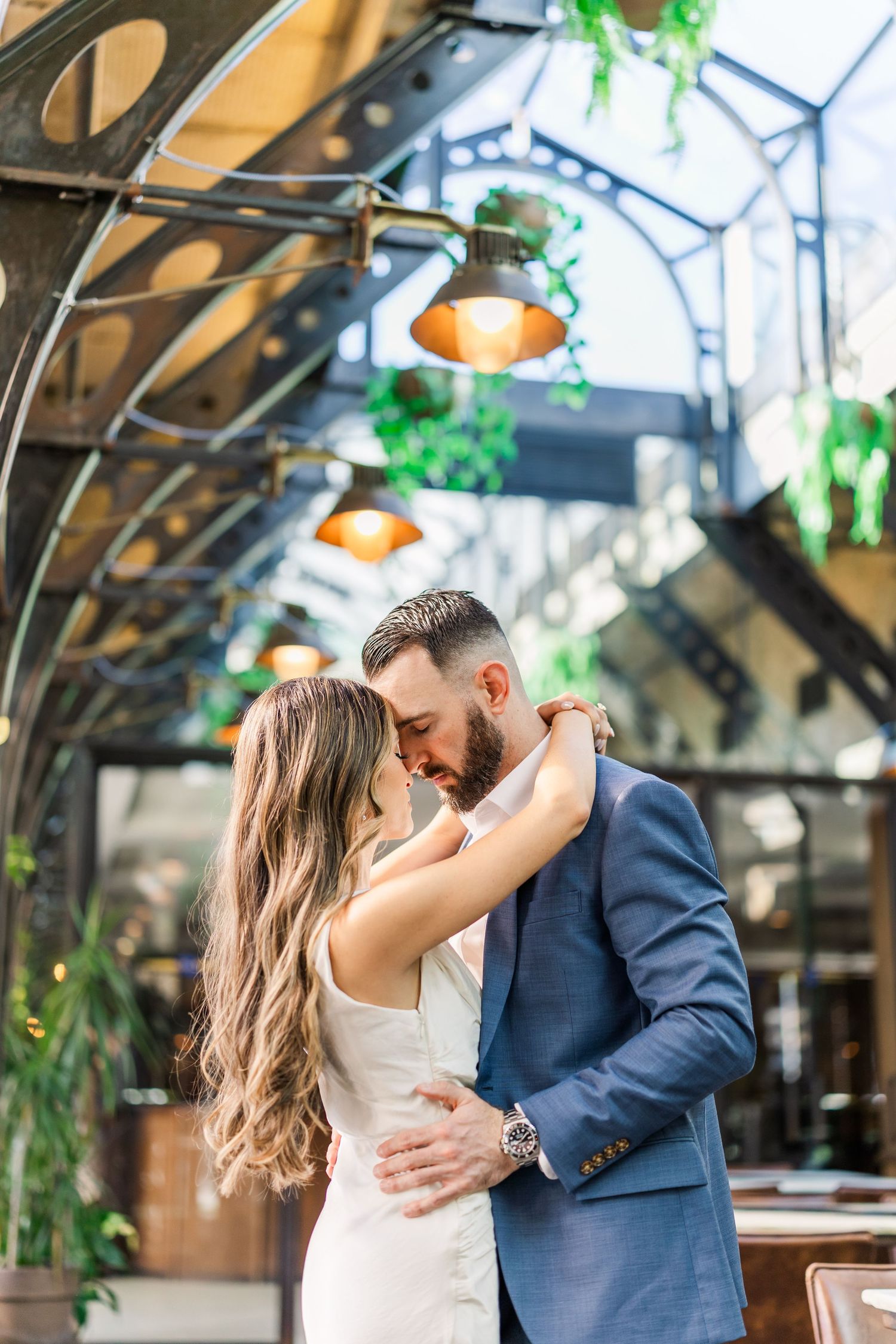 couple laughing and linking arms with white building