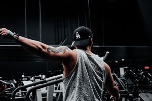 Fitness model showing back muscles in sleeveless hoodie