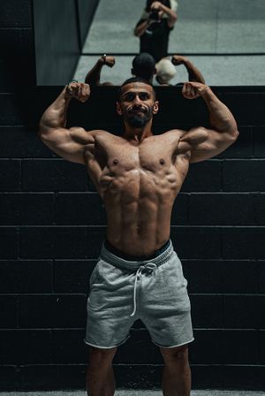 Flexing biceps in gym mirror with shadows and depth