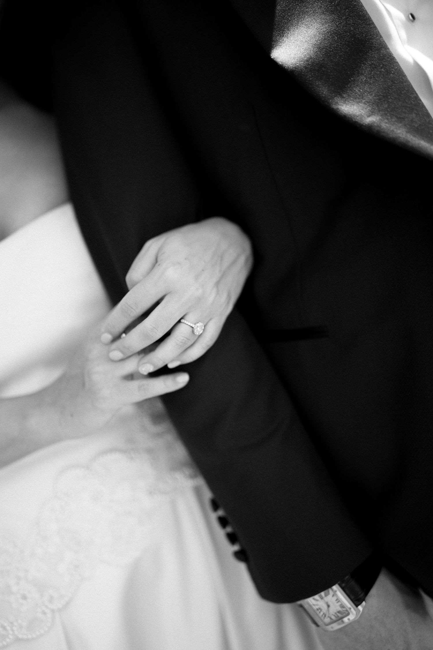 Close-up of bride and groom hands with wedding ring and watch during ceremony.