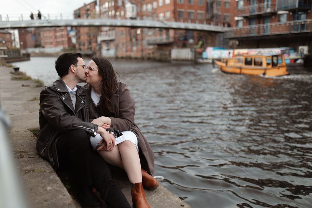 A romantic couple in formal attire shares an intimate moment on a gondola ride along Venice's historic canals. Leeds City Centre Engagement.
