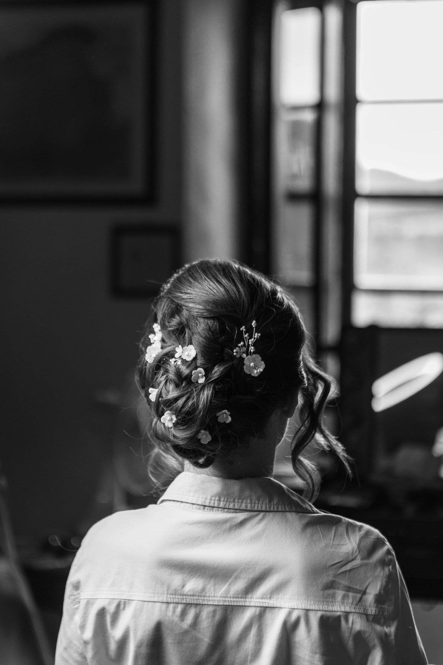 Elegant bridal hairstyle with floral details captured in black and white.