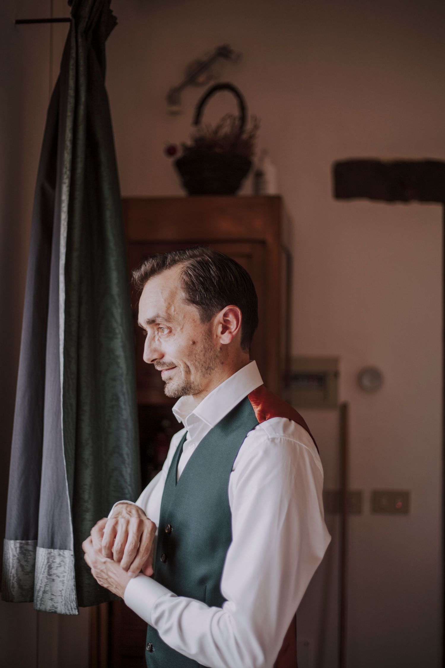 Classic formal attire with green vest captured in intimate indoor setting.