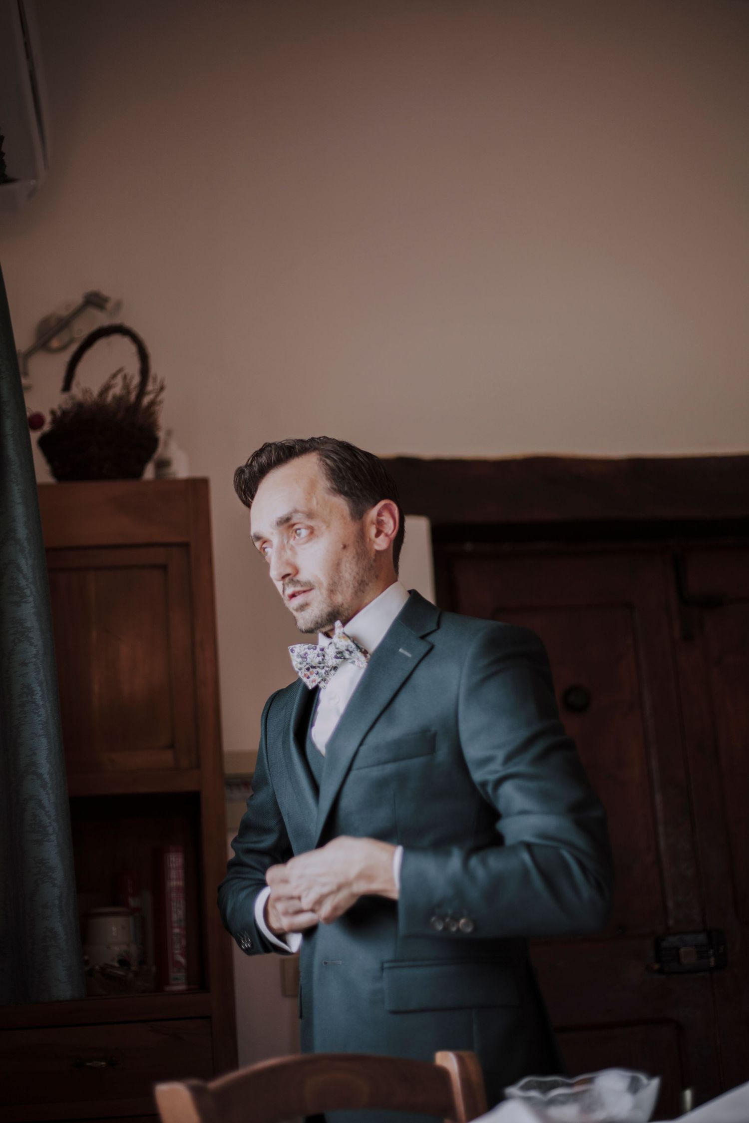 Elegant formal suit and bowtie photographed in warm indoor lighting.