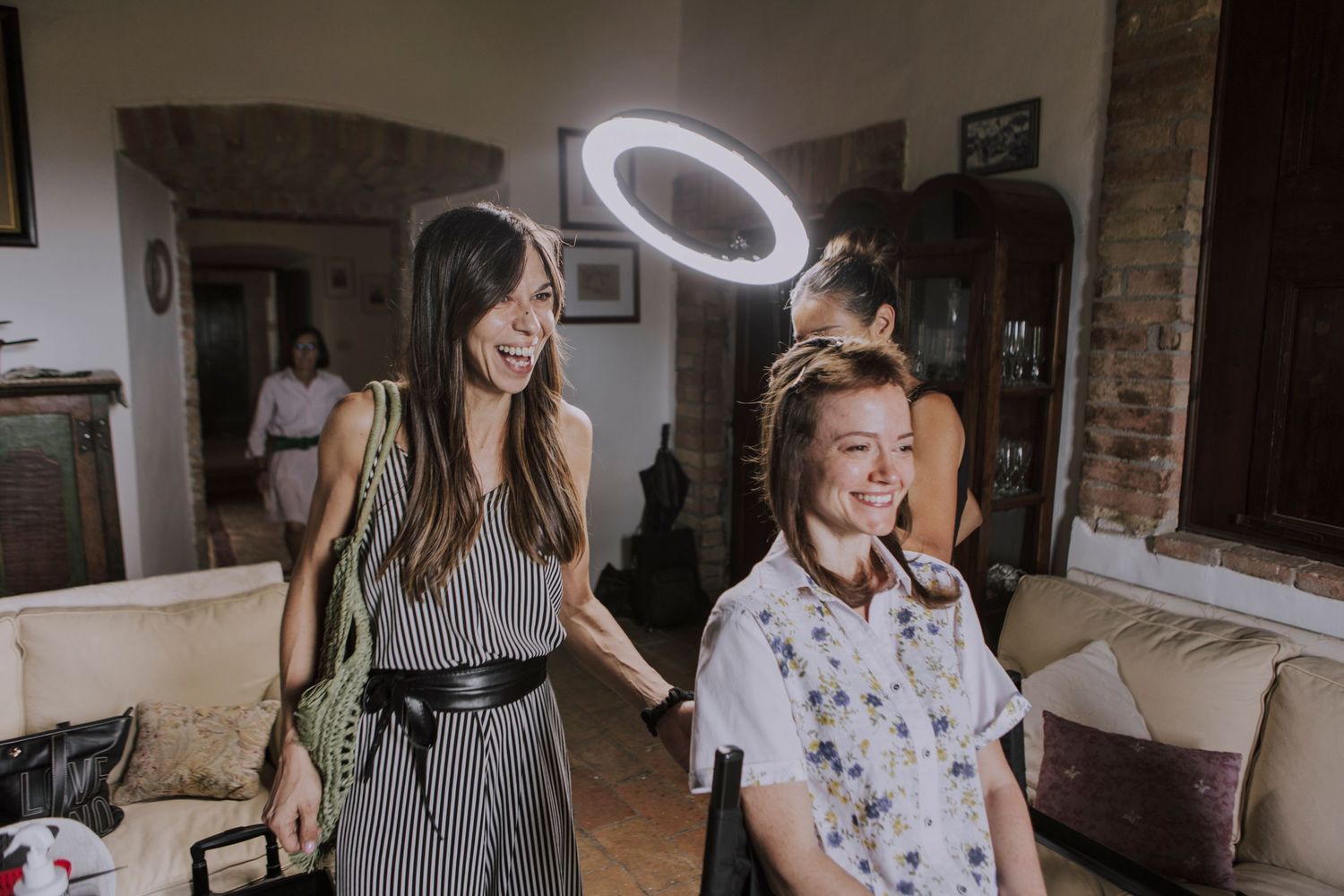Behind-the-scenes preparation moment with ring light illuminating a casual pre-wedding setting.