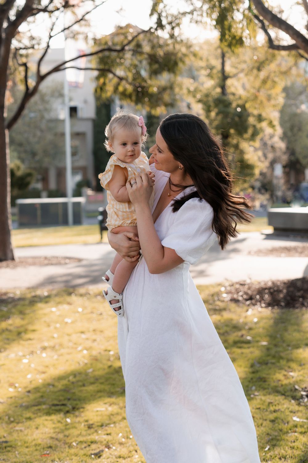 Parent and child sharing tender moment outdoors on sunny autumn day.